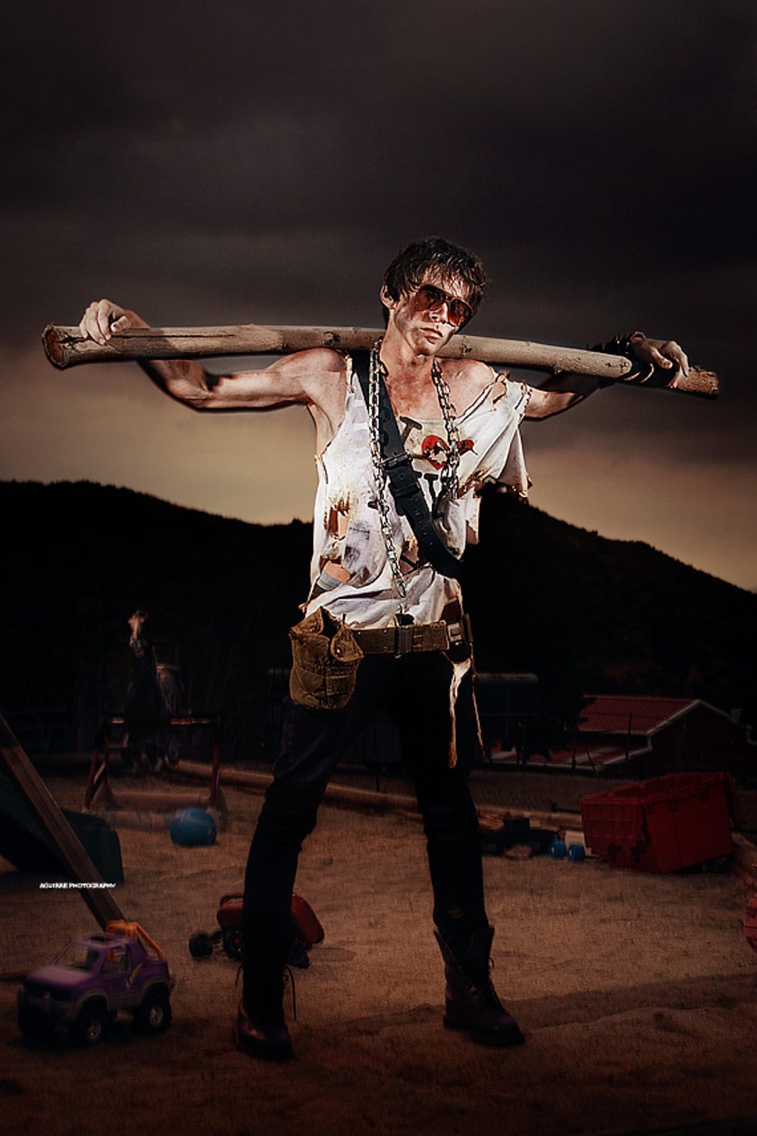 Man in post-apocalyptic costume holding a wooden beam