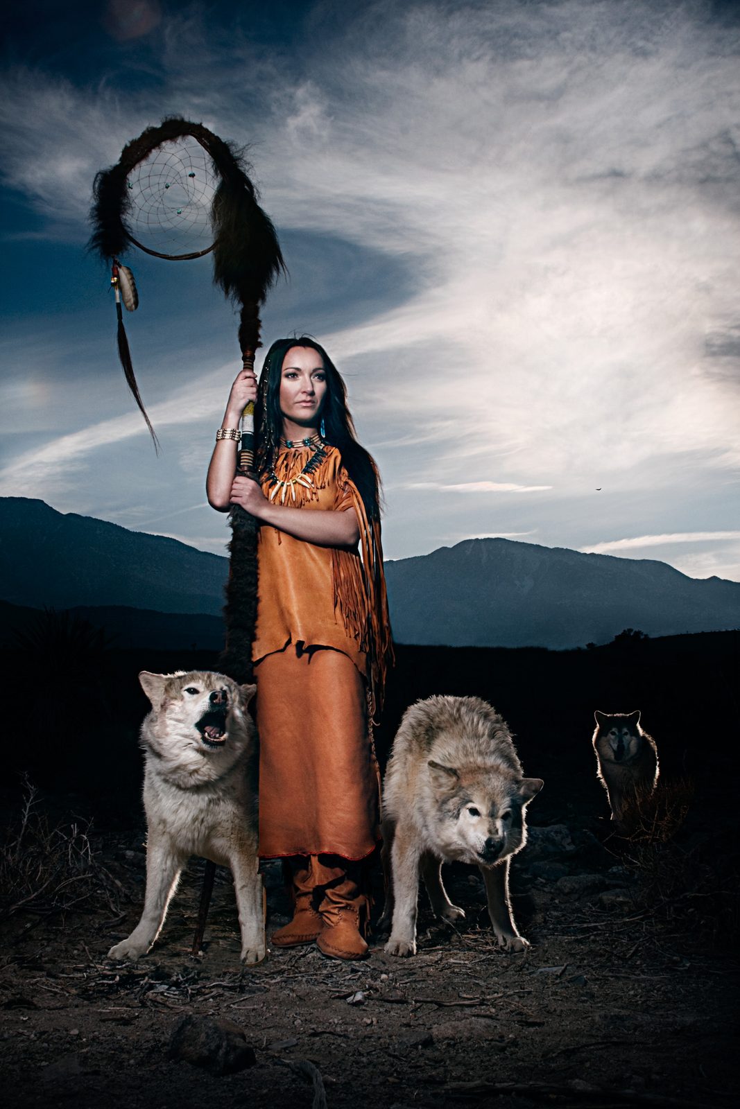 Woman with a dreamcatcher standing between wolves