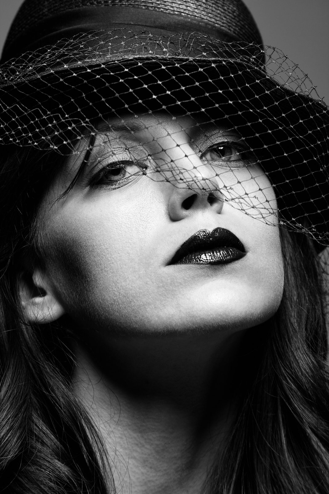 Black-and-white portrait in a veiled hat