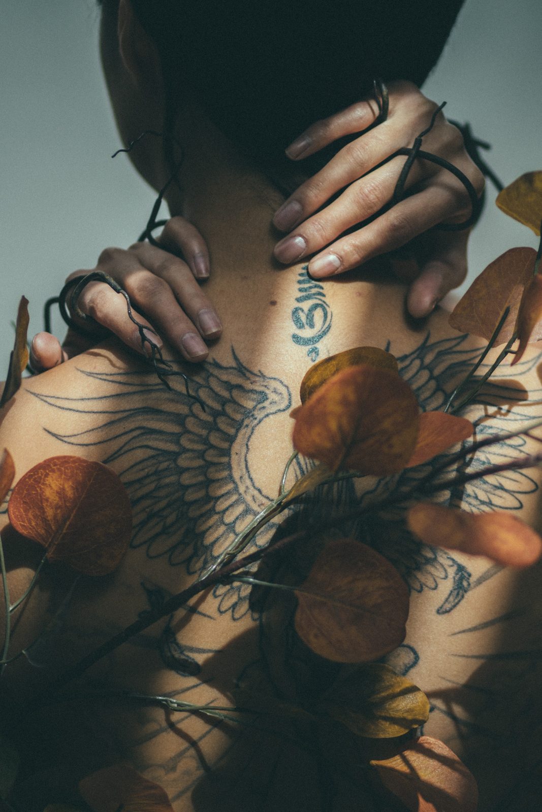 Hands resting on a tattooed back