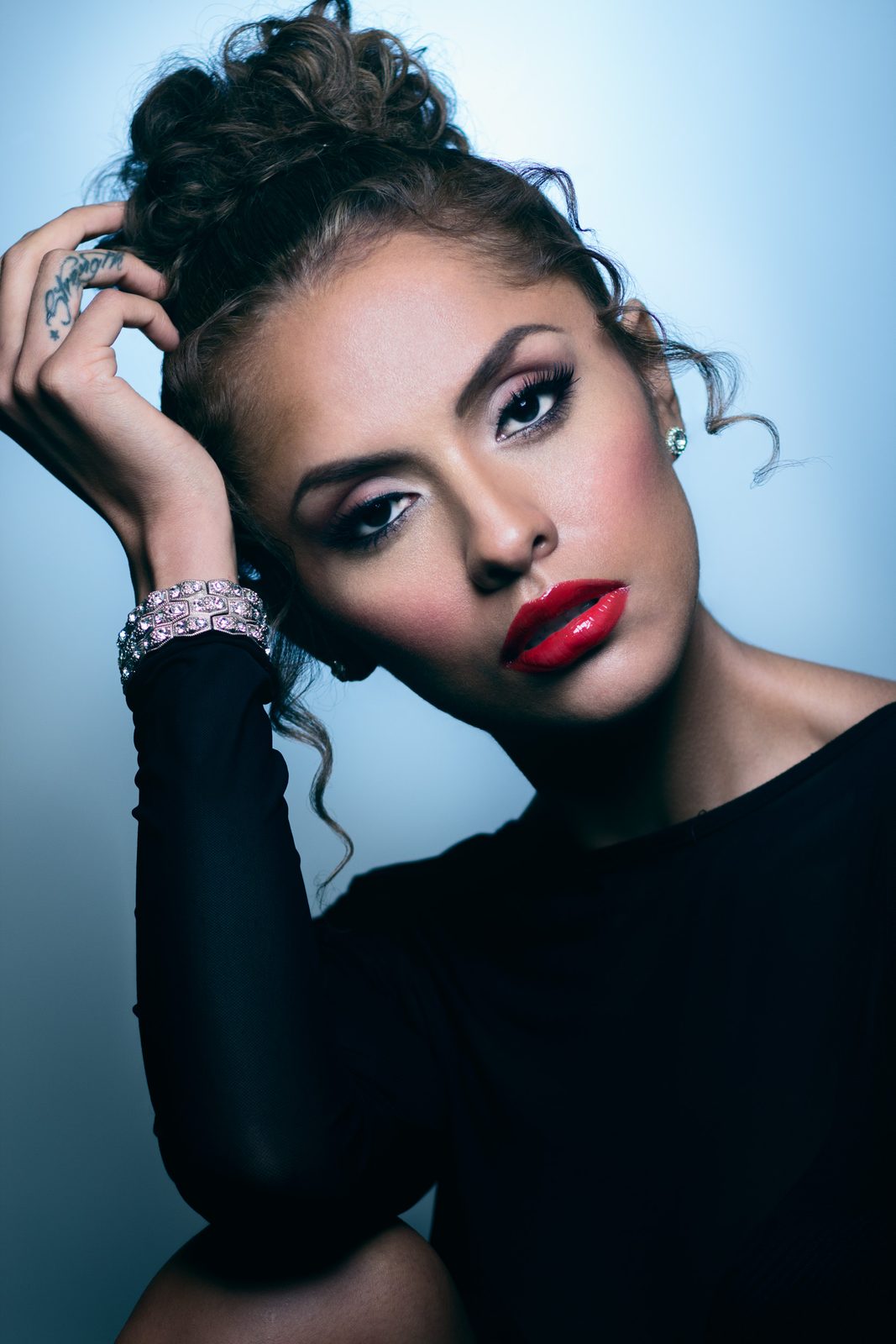 Beauty portrait with red lips against a blue backdrop